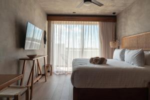 a bedroom with a large bed and a window at TUK Tulum Studios in Tulum
