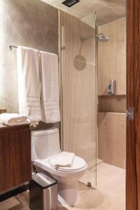 a bathroom with a toilet and a shower with towels at TUK Tulum Studios in Tulum +11 photos