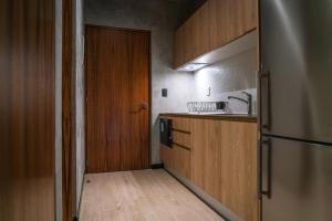 a kitchen with a wooden door and a wooden floor at TUK Tulum Studios in Tulum
