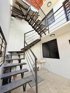 a metal spiral staircase in a building with a bench at El Rinconcito Oaxaca - HiveNB in Santa Cruz Xoxocotlán