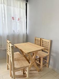 a wooden table and chairs in a room with a curtain at El Rinconcito Oaxaca - HiveNB in Santa Cruz Xoxocotlán