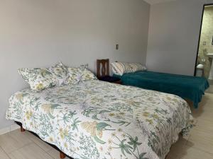 a bedroom with a bed with a comforter on it at El Rinconcito Oaxaca - HiveNB in Santa Cruz Xoxocotlán