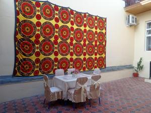 a table and chairs in front of a large painting at Hotel Murodjon in Samarkand