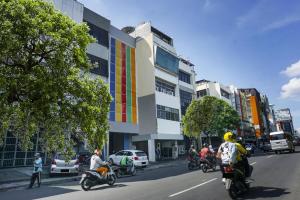 a group of people riding motorcycles down a city street at Hotel O Fiducia Capsule Hotel in Jakarta