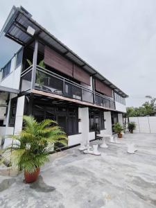 a building with white chairs in front of it at Homestay Daud in Bandar Permas