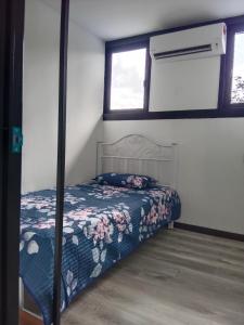 a bedroom with a bed with a floral bedspread at Homestay Daud in Bandar Permas