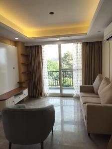 德拉敦Flat in Dehradun的带沙发和大窗户的客厅