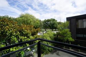 a balcony with a black railing next to a building at Touch of Class CBD, free park in Christchurch