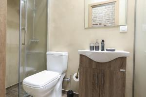 a bathroom with a toilet and a sink and a shower at BELLA CASA del NONNO in Corfu Town +20 photos