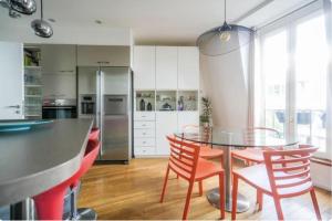 a kitchen with a glass table and red chairs at Sweet home in Paris +1 photo