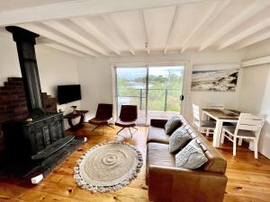 a living room with a couch and a fireplace at Surf Charm in Venus Bay