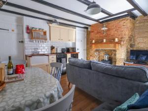 a living room with a couch and a kitchen at Roseberry Cottage in Whitby