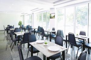 a dining room with tables and chairs and windows at Baan Payai Resort in Ban Pang Kae