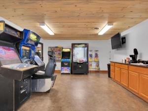 una habitación con 2 juegos de arcade y una cocina en Studio Model Home with Parking, en Pigeon Forge