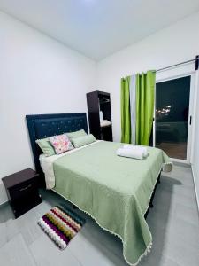 a bedroom with a large bed with a green blanket at San Francisco Luxury Prestige 2 in Juticalpa