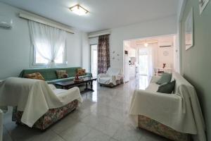 a living room with a green couch and chairs at Sea Zen in Paleo Tsifliki