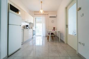 a kitchen with a white refrigerator and a table at Sea Zen in Paleo Tsifliki