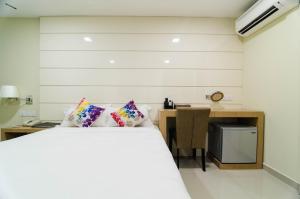 a bedroom with a bed and a desk at Mornington Hotel Sitiawan in Sitiawan