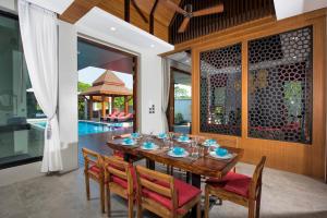 una sala da pranzo con tavolo e sedie in legno di Narintara Private Pool Villas - FREE Tuk-Tuk Service to the Beach! ad Aonang Beach