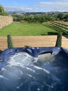 a jacuzzi tub with a view of a field at Luxury Cottage, views of the Lakes with Hot Tub in Cockermouth