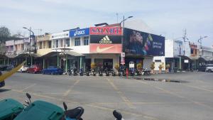 a parking lot with motorcycles parked in front of a building at Sunderland Motel in Kuah