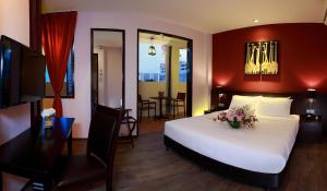 a bedroom with a large white bed and a table and chairs at Kimberley Hotel Georgetown in George Town