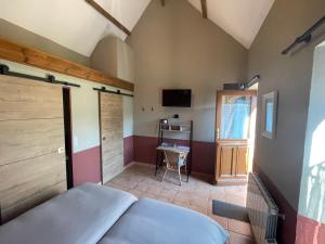 a bedroom with a bed and a tv and a table at Domaine de Collen in Lépine