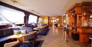 um restaurante com sofás e mesas e um bar em Hotel Caminetto em Folgarida