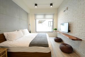 魚池鄉的住宿－日月潭山慕藝旅 Sun Moon Inn，一间卧室设有一张床和砖墙