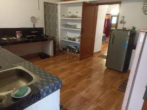 a kitchen with a sink and a refrigerator at The Lungi Vibe in Varkala
