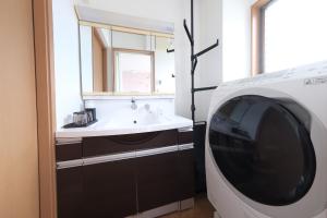 a washing machine in a bathroom with a sink at Villa Lotus in Kamakura