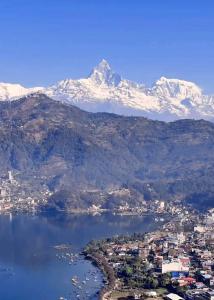 a view of a city and a lake with snow capped mountains at Sakar home stay in Pokhara