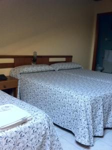 two beds sitting next to each other in a bedroom at Hotel Pinzon in Baiona