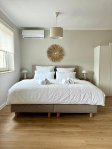 una camera da letto con un letto grande con lenzuola bianche di Zentral I Business I Boxspring I Klima I Parkplatz a Illingen