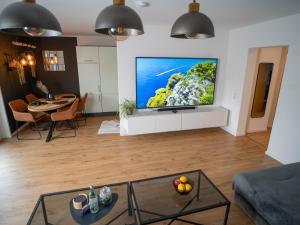 a living room with a flat screen tv on a wall at MOREHOME Sonnenterrasse & Heimkino Switch 2 in Mindelheim