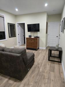 a living room with a couch and a flat screen tv at Cozy Maison Apt #8 in Gatineau +2 photos
