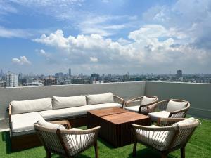 a couch and chairs on a balcony with a view at Pearly Breeze Guest Room in Dehiwala