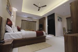 Un dormitorio con una cama y un escritorio en una habitación. en Hotel Vista Suites, en Tezpur