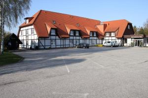 ein großes Gebäude mit einem davorliegenden Parkplatz in der Unterkunft Hotel Mecklenburger Mühle Garni in Wismar