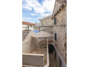 eine Außenansicht eines Gebäudes mit Schirm in der Unterkunft Stone Apartment Primosten in Primošten