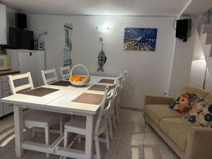 eine Küche mit einem weißen Tisch und Stühlen sowie einem Sofa in der Unterkunft Stone Apartment Primosten in Primošten + 15 Fotos