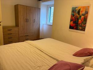 ein Schlafzimmer mit einem Bett und einem Gemälde an der Wand in der Unterkunft Stone Apartment Primosten in Primošten
