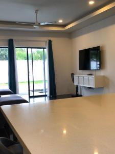 a living room with a large table and a flat screen tv at Villa Koh Mzé, 2 bedrooms with peaceful pool in Hua Thanon Beach +16 photos