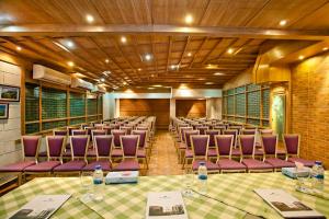 une salle de conférence avec des chaises et des tables violettes et des bouteilles d'eau dans l'établissement Well Park Residence Boutique Hotel & Suites, à Chittagong