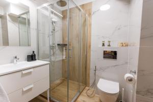 a bathroom with a shower and a toilet and a sink at Zeus Apartments Lublin in Lublin +56 photos