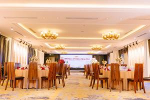 ein Konferenzraum mit Tischen und Stühlen sowie einer Projektionsfläche in der Unterkunft Green Dragon Boutique Hotel in Cẩm Phả