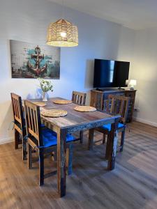 a dining room table with chairs and a television at Familienwohnung-Harbour-View in Orth +26 photos