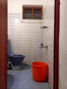 a bathroom with a toilet and a bucket at The Lungi Vibe in Varkala