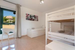 Un dormitorio con dos literas y una silla. en El refugio, en La Oliva 22 fotos más