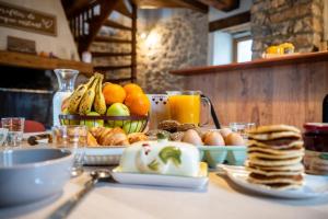 a breakfast table with pancakes and fruit and juice at Maison de village au cœur des remparts in Sainte-Eulalie-du-Cernon +3 photos